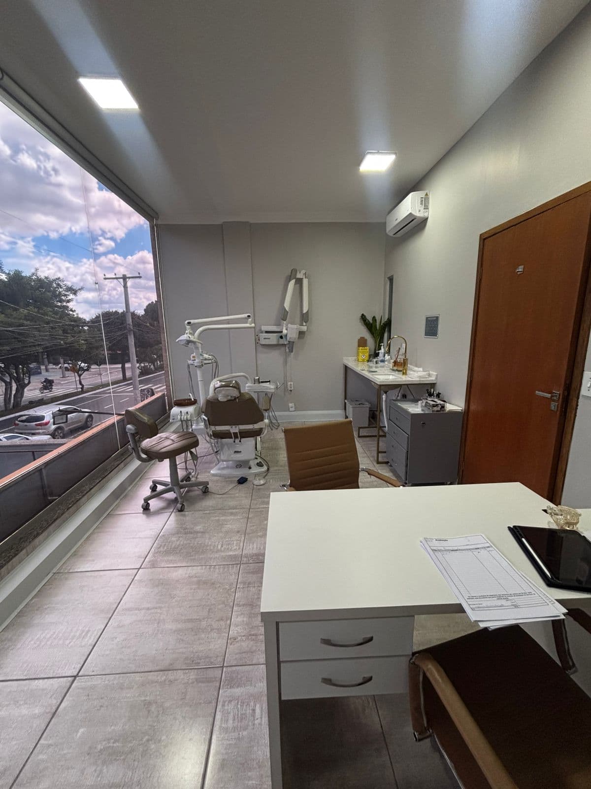 Bancada de apoio ao lado da cadeira odontológica, com instrumental organizado